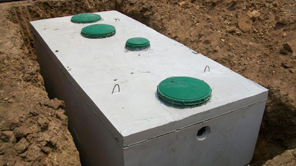 New septic tank with green access lids ready for installation